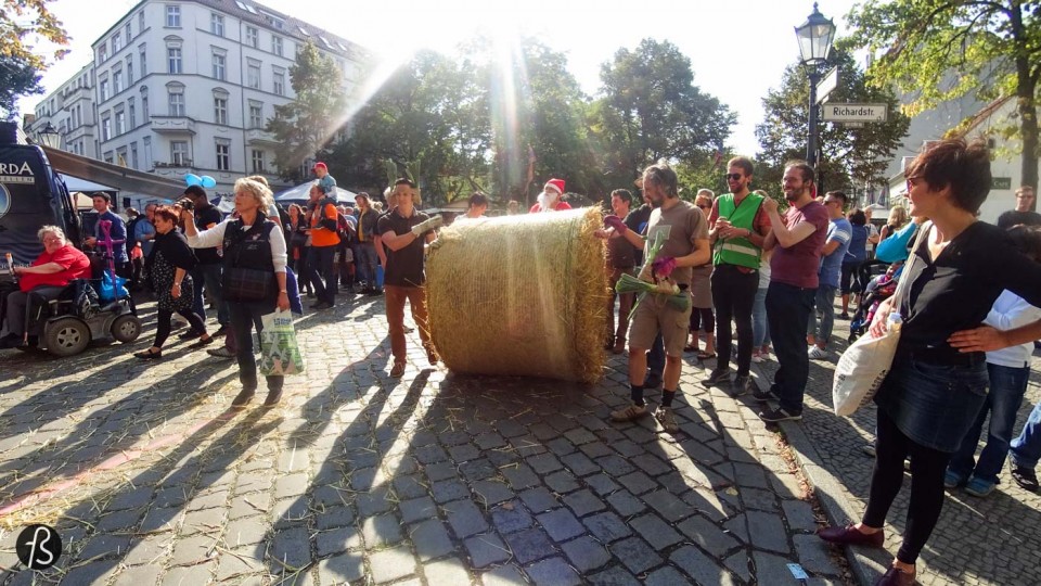 On September 12, 2015, we were in the middle of Rixdorf to see what could be only described as something really weird. Weird because we never imagined to see groups of people running around huge straw bale rolls on the streets of the German capital. But it happened in front of us and it was so cool we had to write about it here. But, before we say anything, we have to explain to you why this exists in the streets of Old Neukölln. This is Popraci.