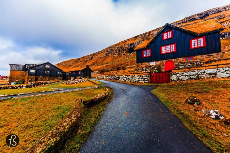 We didn’t know it back when we visited Kirkjubøur Village but the beautiful black wood house with red doors is the oldest still inhabited wooden houses of the world. Called Kirkjubøargarður, which means Yard of Kirkjubøur in Faroese, is the largest farm in the Faroe Islands and it has always been. The building dates back to the 11th century and it was the episcopal residence and seminary of the Diocese of the Faroe Islands since then.