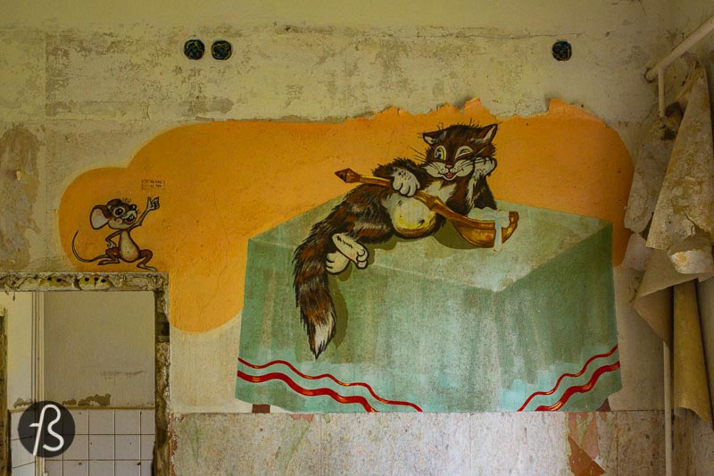But the most fantastic mural that we found came to us by accident. We knew that there were some Soviet paintings in a place underground, in a flooded hallway, but we were not sure where was this located. We got lucky when we entered one of the many similar buildings and saw a few massive tires blocking a flight of stairs. We took our flashlights and decided to investigate. And, there it was, a Soviet flag and some soldiers painted into the wall of a flooded hallway in complete darkness. We didn't manage to take a good picture of it due to the dark, the weird angle we were in and the weirdness of it all but we found it.